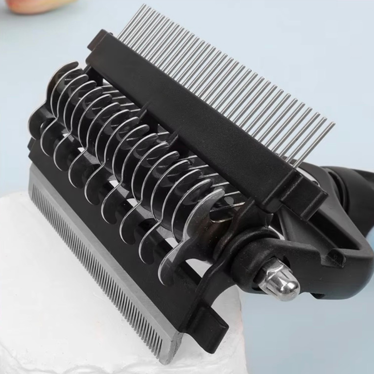 Pet grooming comb with metal teeth on a light blue background